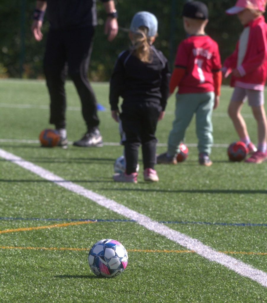 Valmentaja ja junioripelaajia FC Hollolan futisharjoituksissa